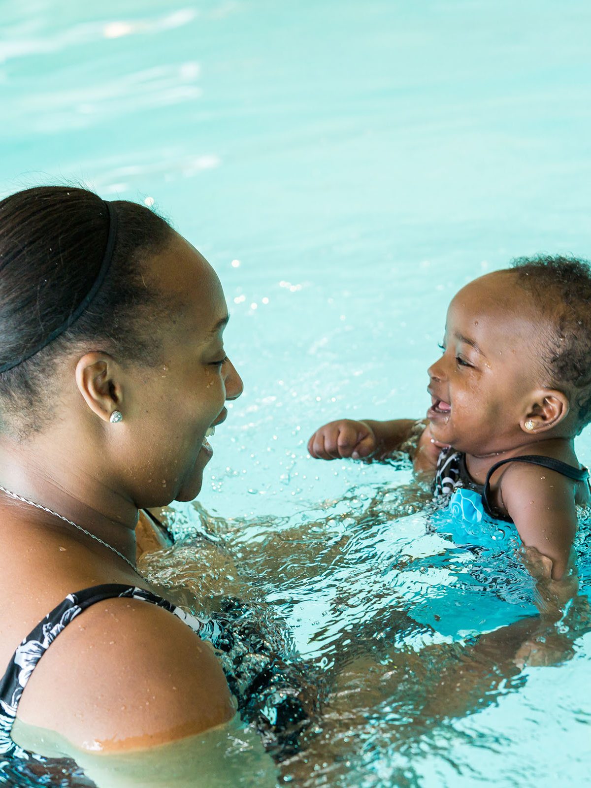 Women swimming with her child at a family fitness center